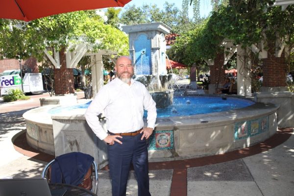 Family law attorney AJ Grossman standing in front of a fountain