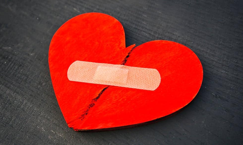 torn red heart taped together with bandaid
