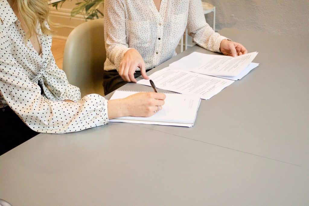 two women chatting over paperwork