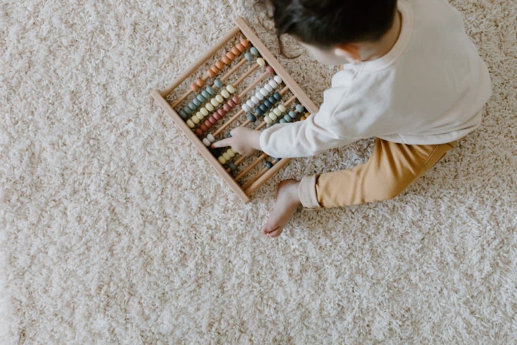 toddler playing with toy on carpet