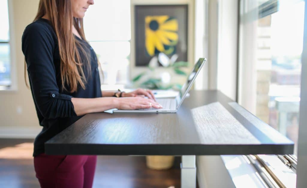 woman at standing desk using laptop