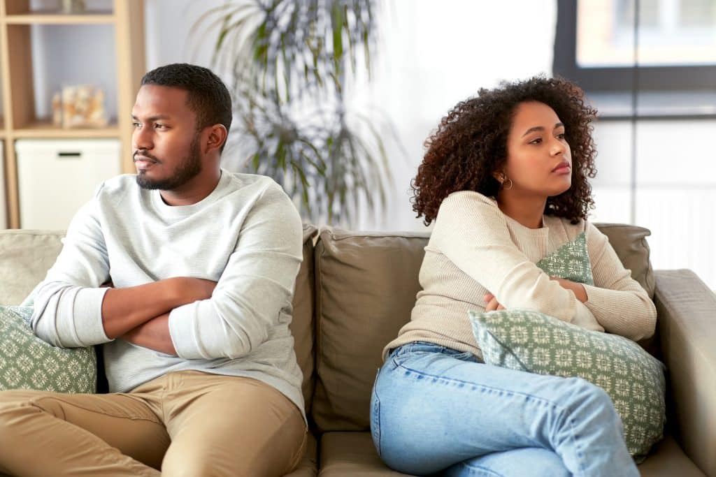 Man and woman on couch turned away from each other