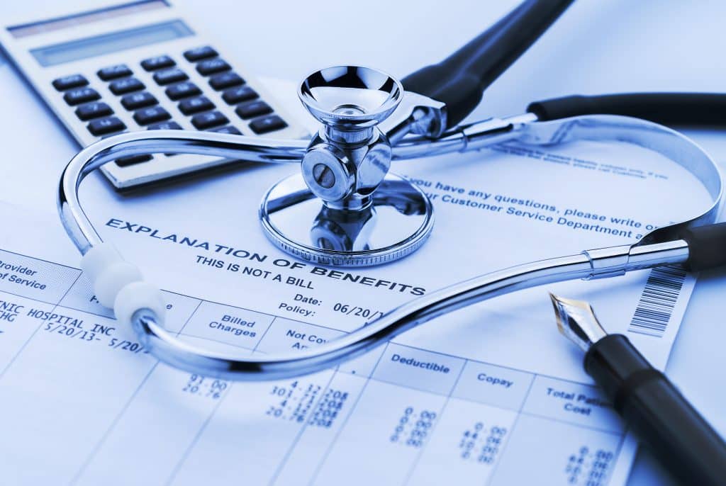 stethoscope and calculator on medical bill
