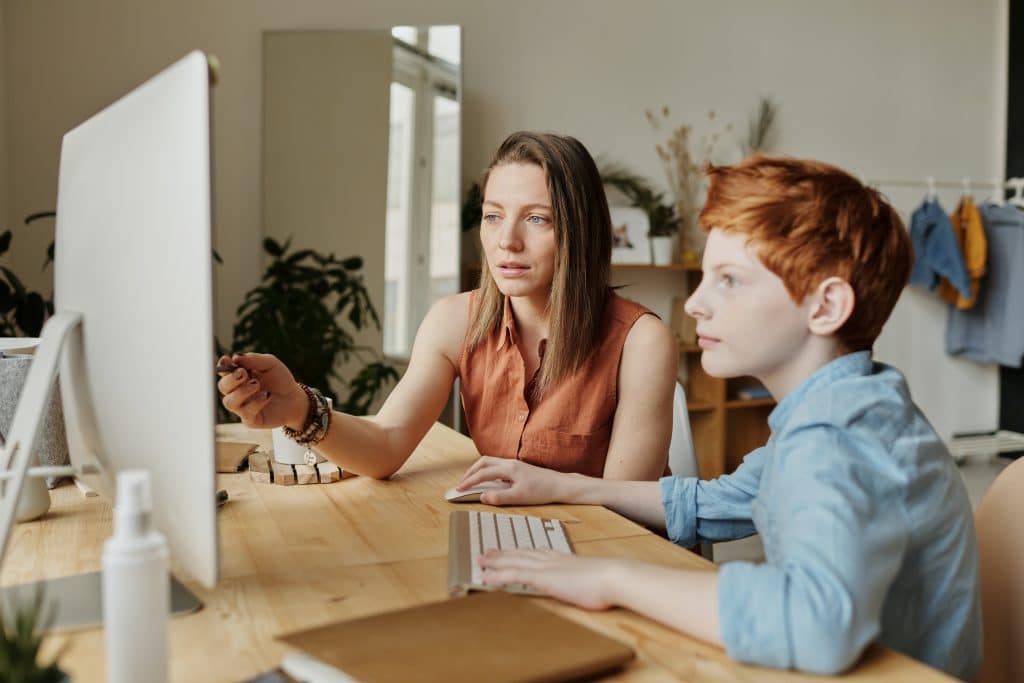 woman helping son on computer
