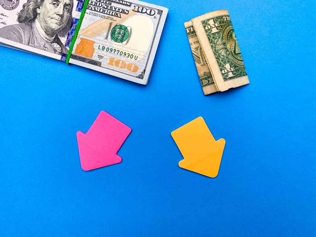 cash on blue background with pink and yellow arrows pointing away