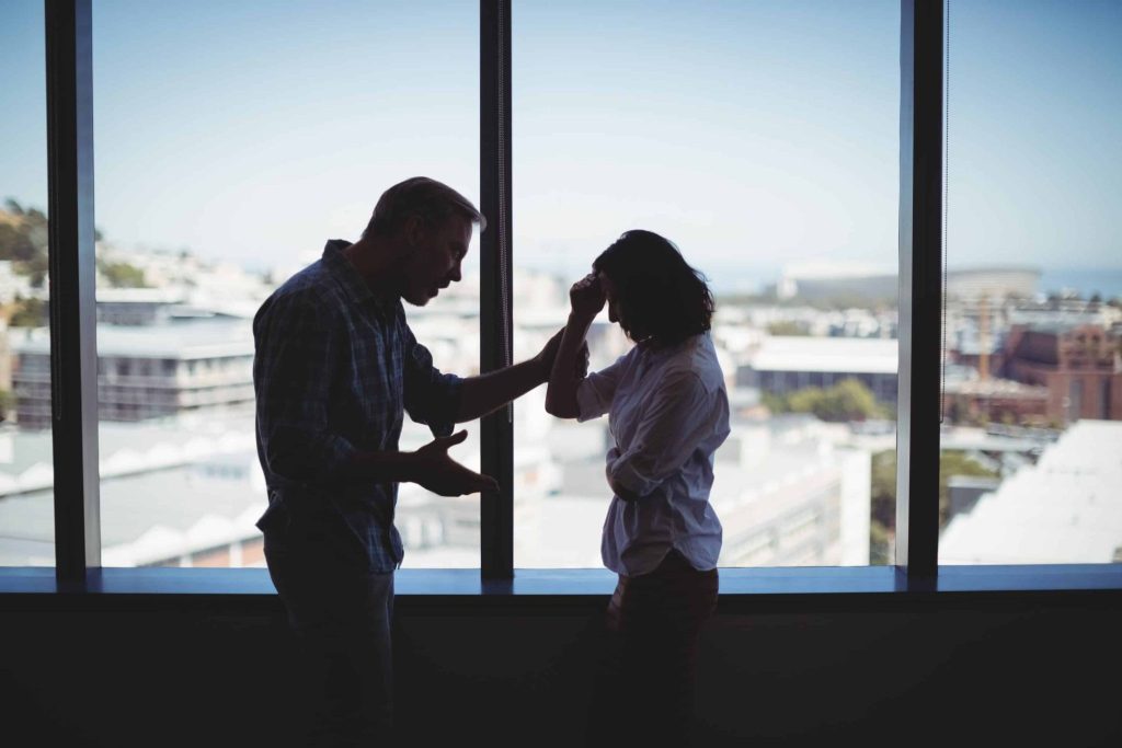 Coworkers arguing near a window in their office