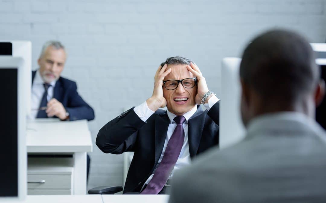 selective focus of stressed businessman at workplace in office