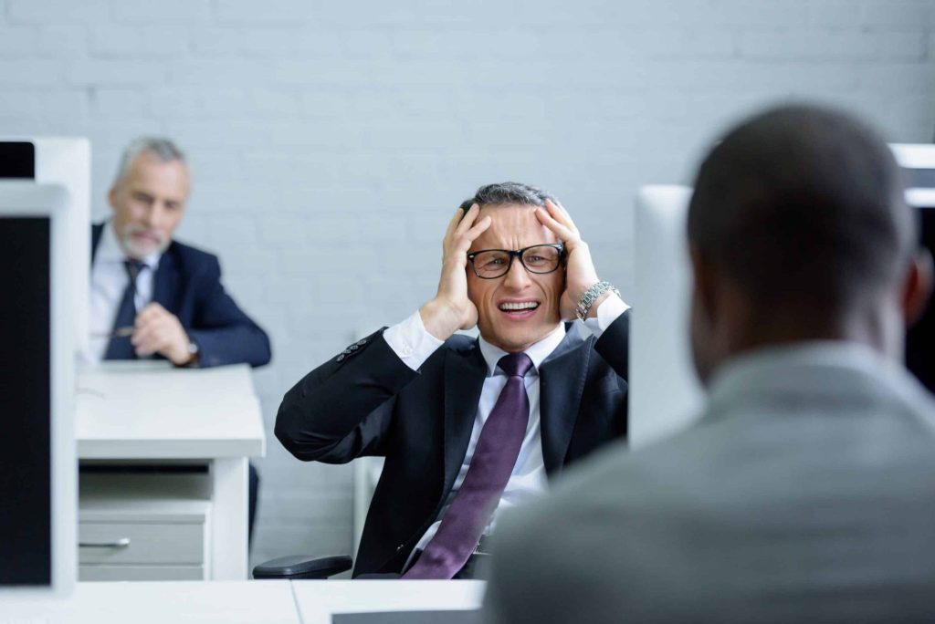 selective focus of stressed businessman at workplace in office