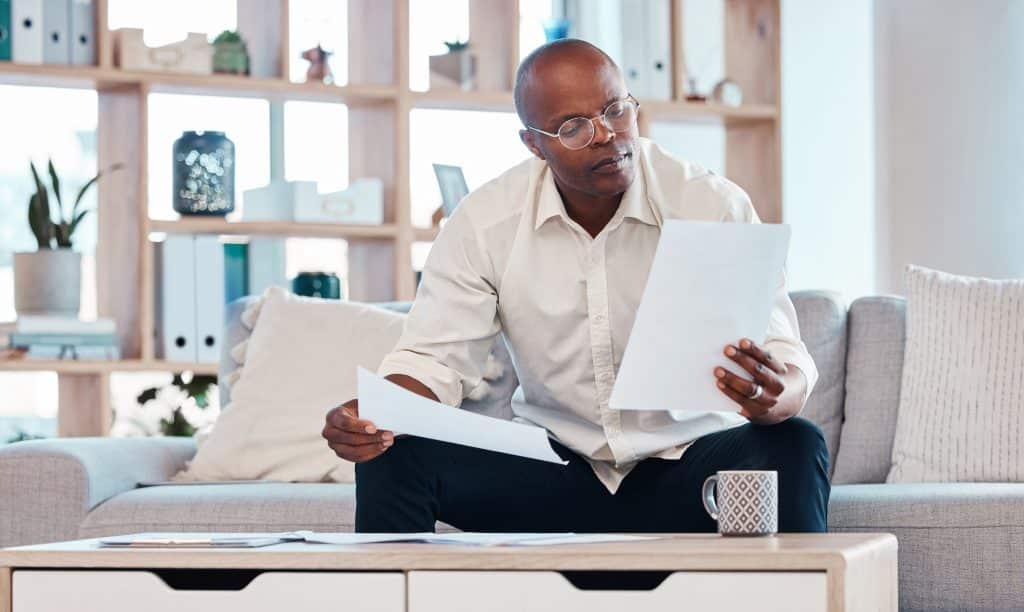 Man reviewing paperwork at home