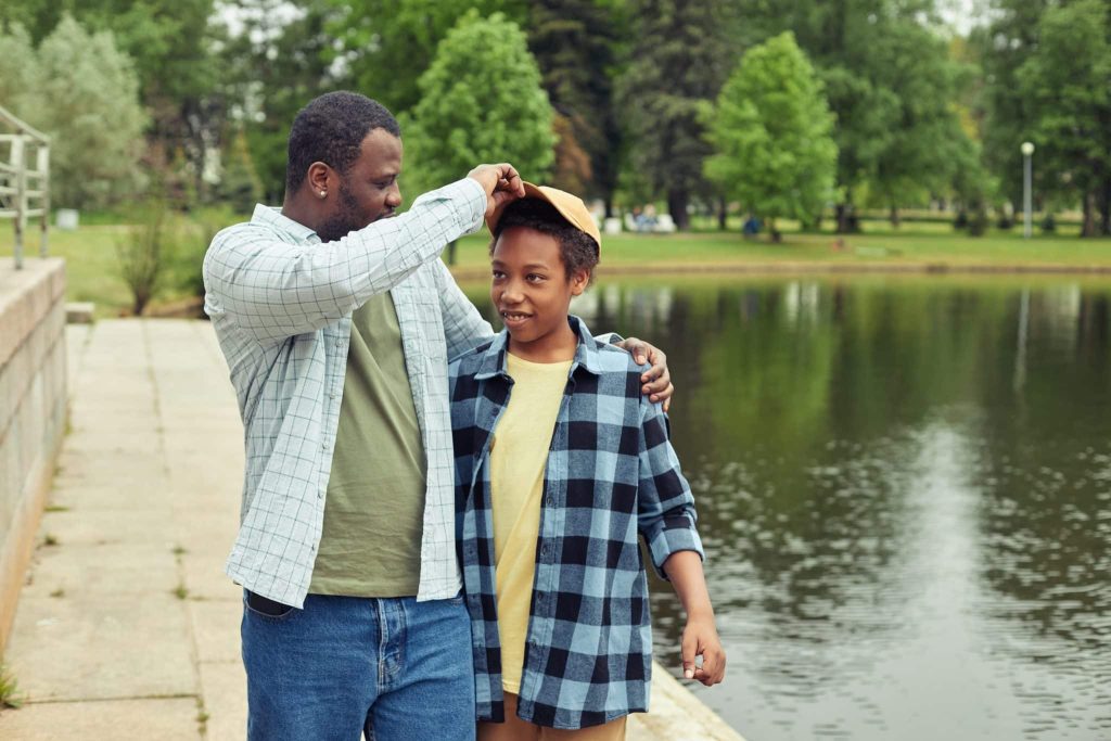 dad walking in park with teen son
