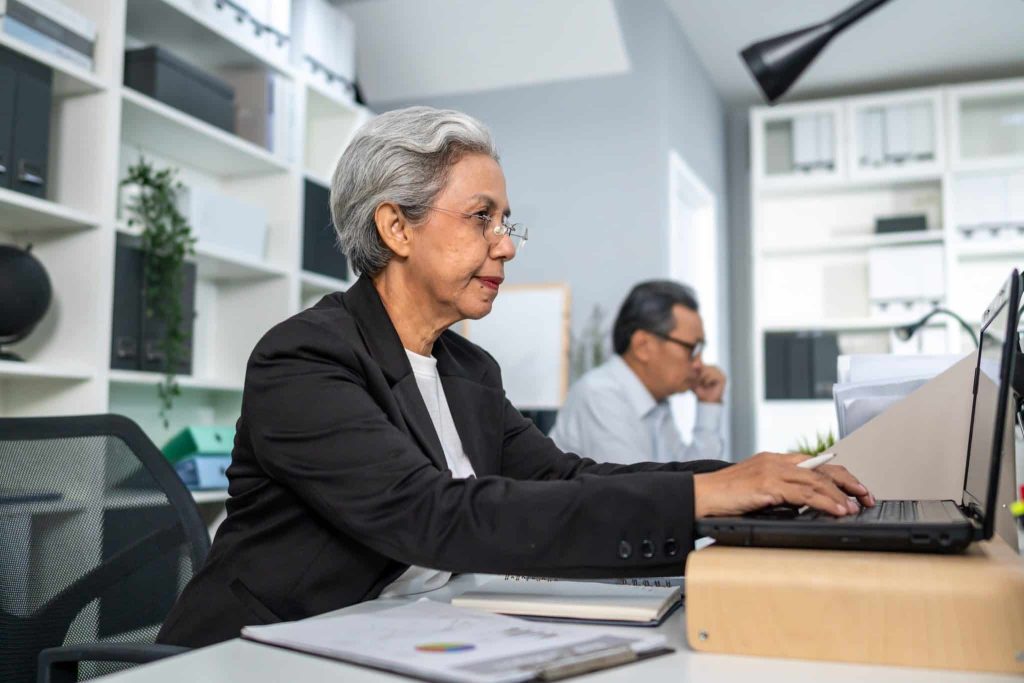 older woman working on office computer